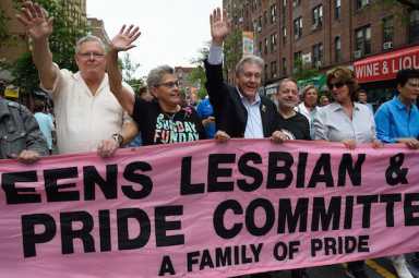 Daniel Dromm (center) holds the original Queens Pride banner at the borough's 2017 march.