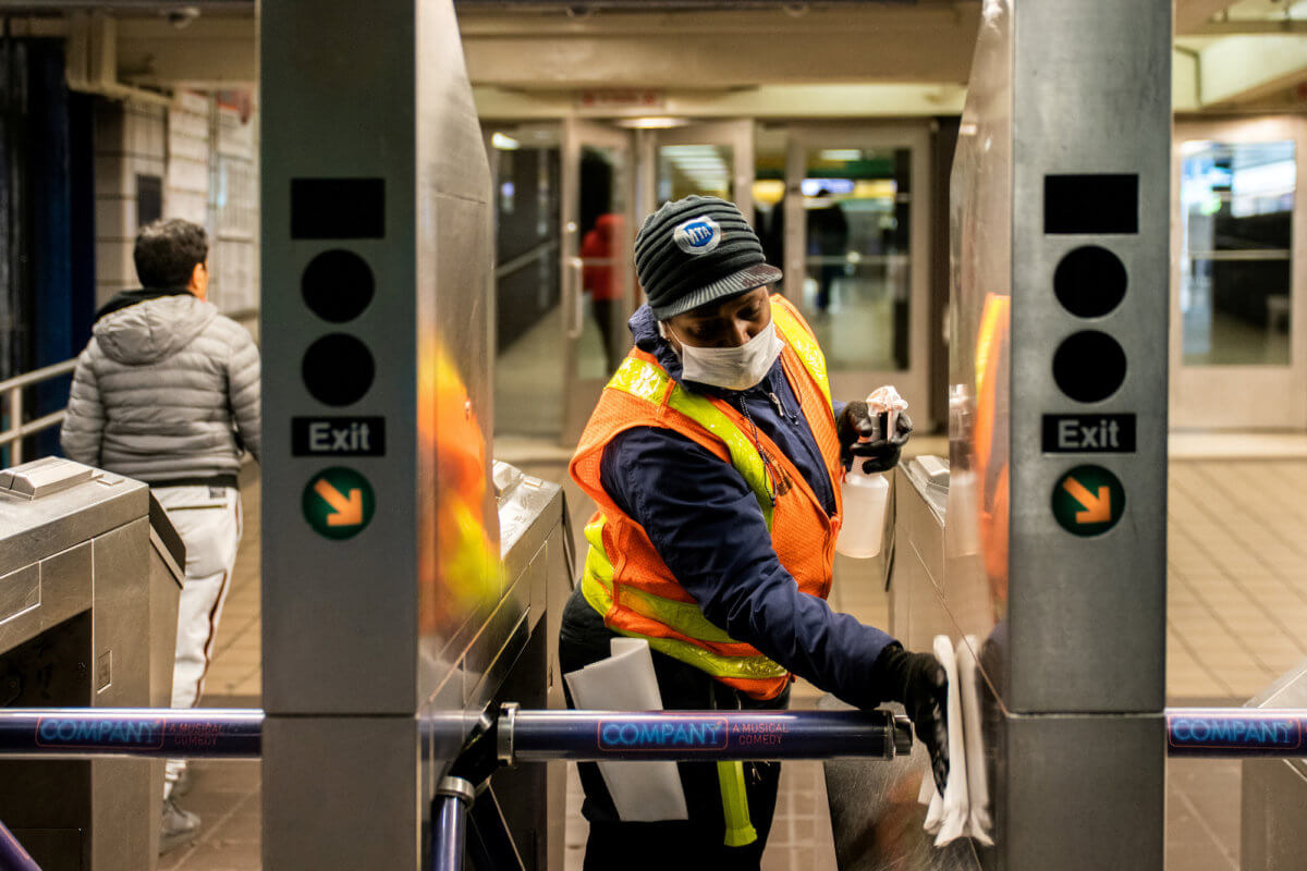 FILE PHOTO: An MTA transit worker cleans a nearly empty Times Square – 42nd street subway station following the outbreak of coronavirus disease (COVID-19) in New York City