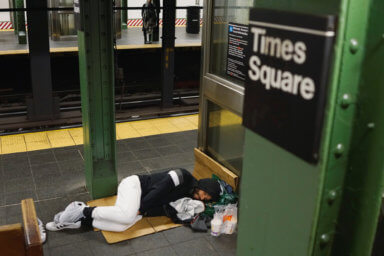 A man who is living in the New York subway system sleeps in a relatively empty subway station as the outbreak of the coronavirus disease (COVID-19) continues in the subways of New York