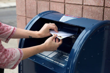FILE PHOTO: An individual mails letters through the U.S. Postal Service (USPS) in Philadelphia