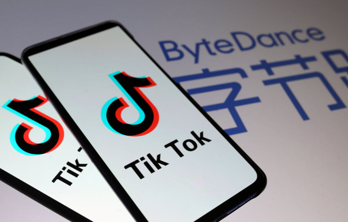 Tik Tok logos are seen on smartphones in front of displayed ByteDance logo in this illustration