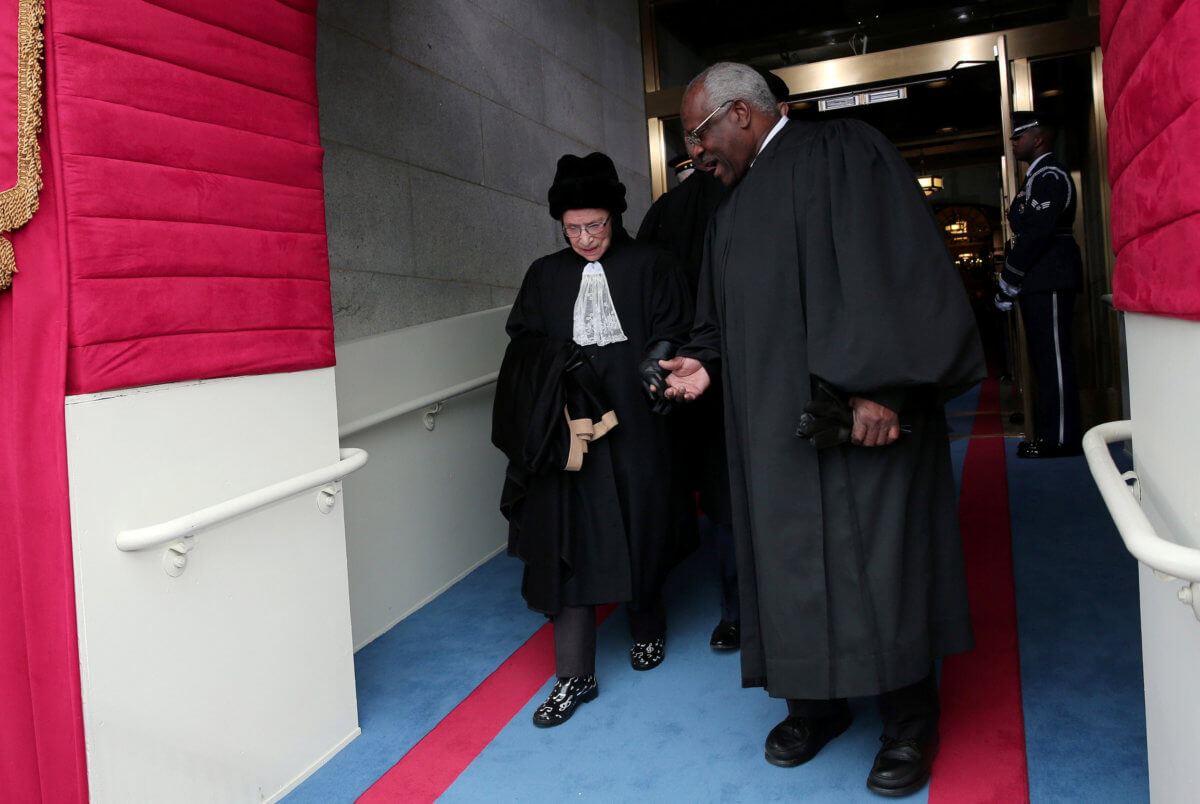 FILE PHOTO: Supreme Court Justices Ruth Bader Ginsburg and Clarence Thomas arrive for the presidential inauguration on the West Front of the U.S. Capitol in Washington