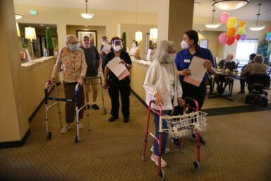 Residents line up to receive the coronavirus disease (COVID-19) vaccine at the Brightwater Senior Living community in Highland