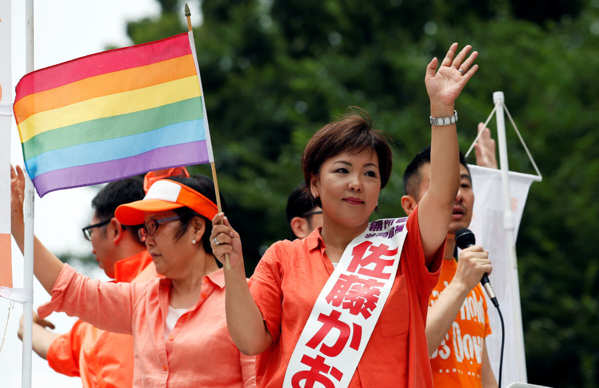 Sato, independent candidate running for the upcoming upper house election, holding a rainbow flag, wave as Taniyama, gay supporter of Sato from Nakano LGBT Network Nijiiro, speaks during a campaign for the July 10 upper house election in Tokyo