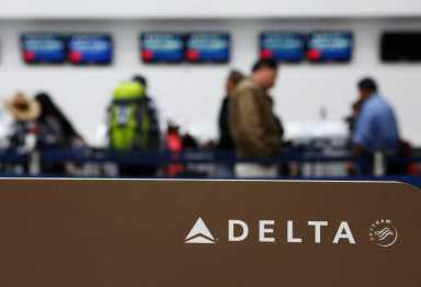 Passengers check in at a counter of Delta Air Lines in Mexico City