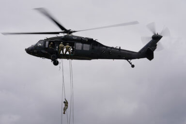 A soldier attending The United States Army Air Assault School rappels from a UH-60 Blackhawk helicopter at Fort Campbell