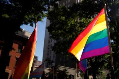 A rainbow flag, commonly known as the gay pride flag or LGBT pride flag, blows in the wind inside Christopher Park outside the Stonewall Inn in New York