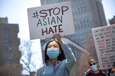 People participate in a Stop Asian Hate rally at Columbus Park in New York