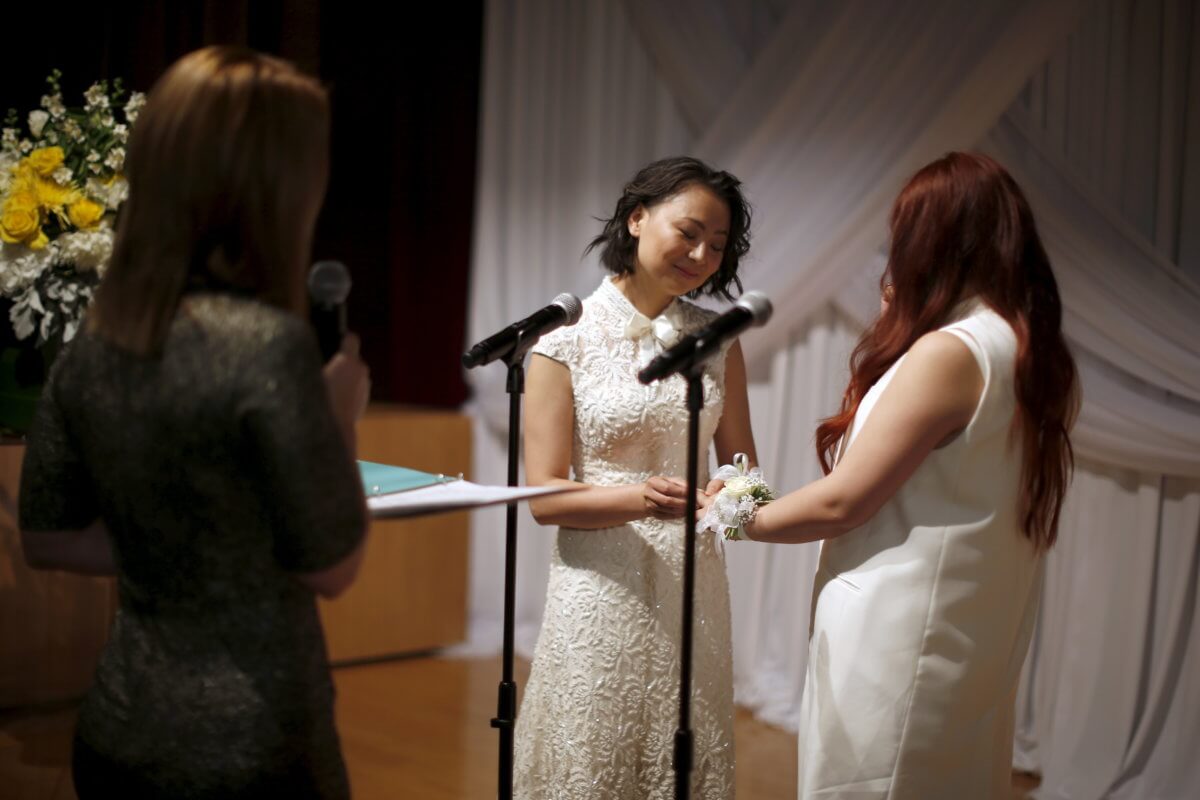 Xu Na and  Xue Mengyao exchange rings at a group wedding for same-sex couples in West Hollywood