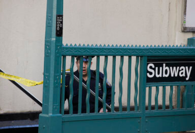 A NYPD officer stands guard near the Penn Station subway entrance where streets have been closed following an early morning shooting in Manhattan New York