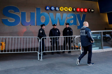 NYPD officers stand outside the New York Port Authority Bus Terminal subway station entrance after reports of an explosion, in New York City