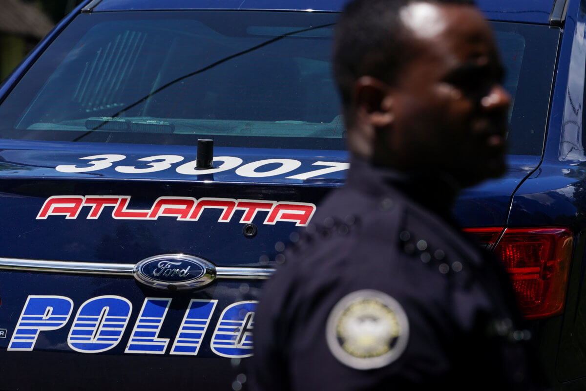 An Atlanta Police Department officer is seen in front of his cruiser in Atlanta