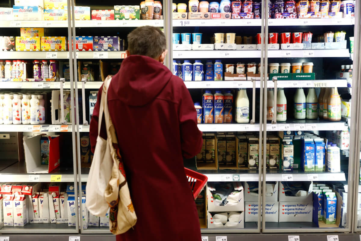 A customer looks at a shelve with dairy products at a Rewe grocery store in Potsdam