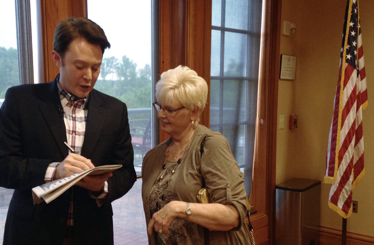 Democratic nominee Aiken signs an autograph for a constituent after a campaign forum in Cary