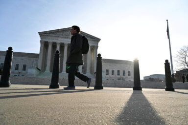 FILE PHOTO: Person walks down the sidewalk near the U.S. Supreme Court building in Washington
