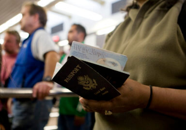 FILE PHOTO: A woman holds passports while waiting to cross at the San Ysidro border crossing