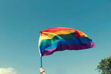 Hands holding rainbow flag of Pride in the during the Sofia Pride parade Selective focus