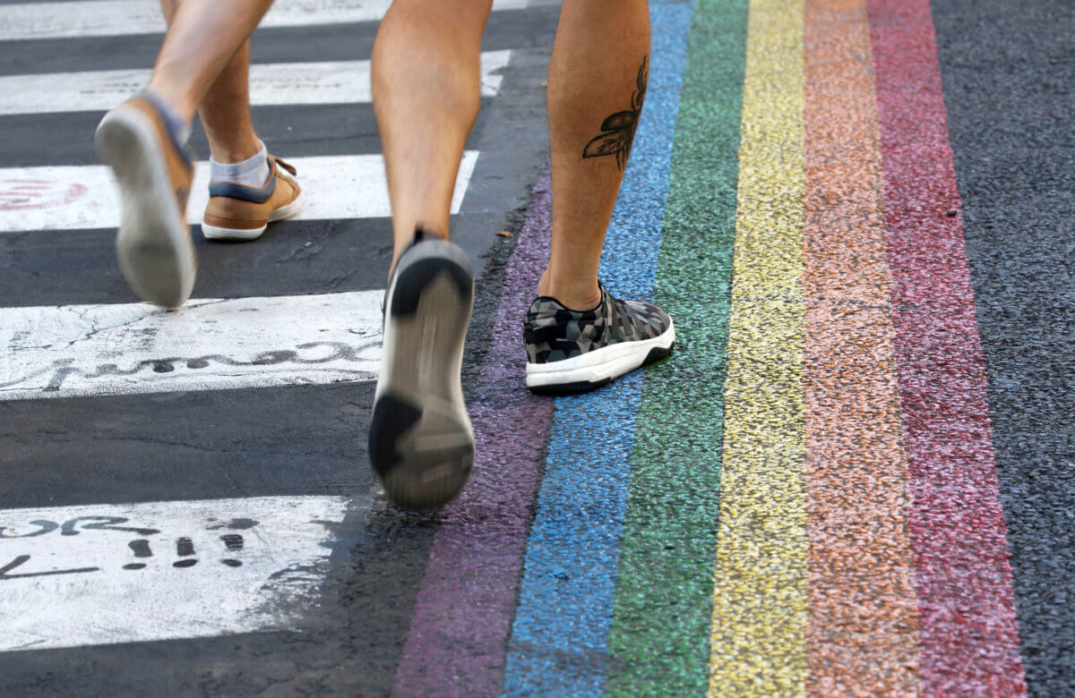 Crosswalks, painted as a rainbow flag, are pictured in the street near the Gay Games village at the Hotel de Ville city hall in Paris