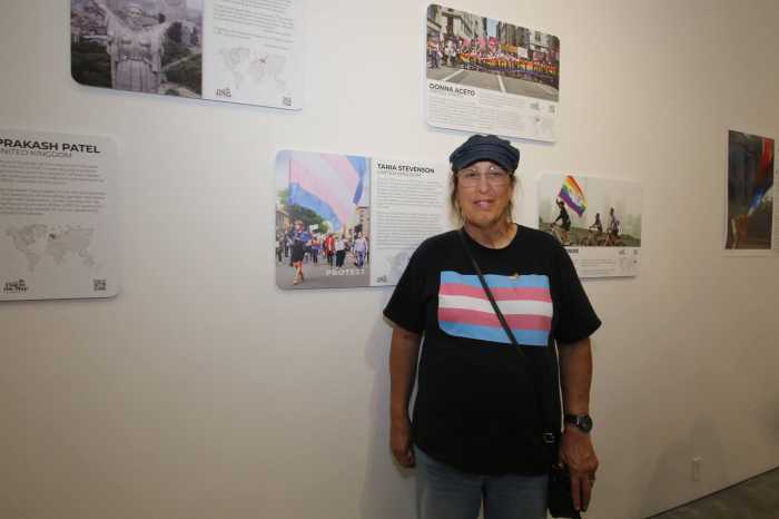 Trans Flag creator Monica Helms stands next to portraits with her flag in 2022.