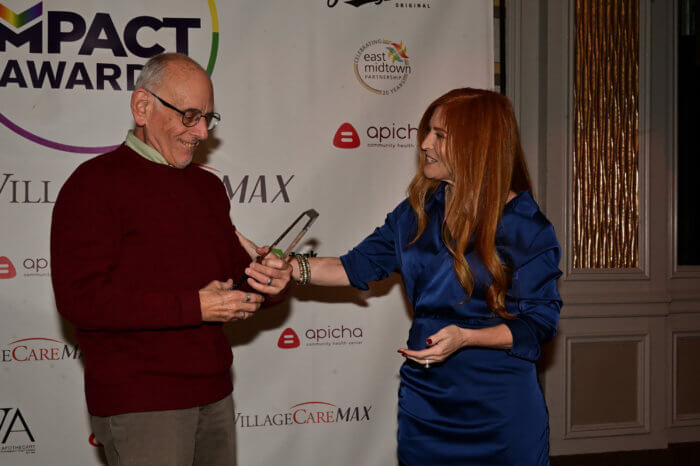 Elizabeth Aloni hands an Impact Award to honoree Burt Lazarin.
