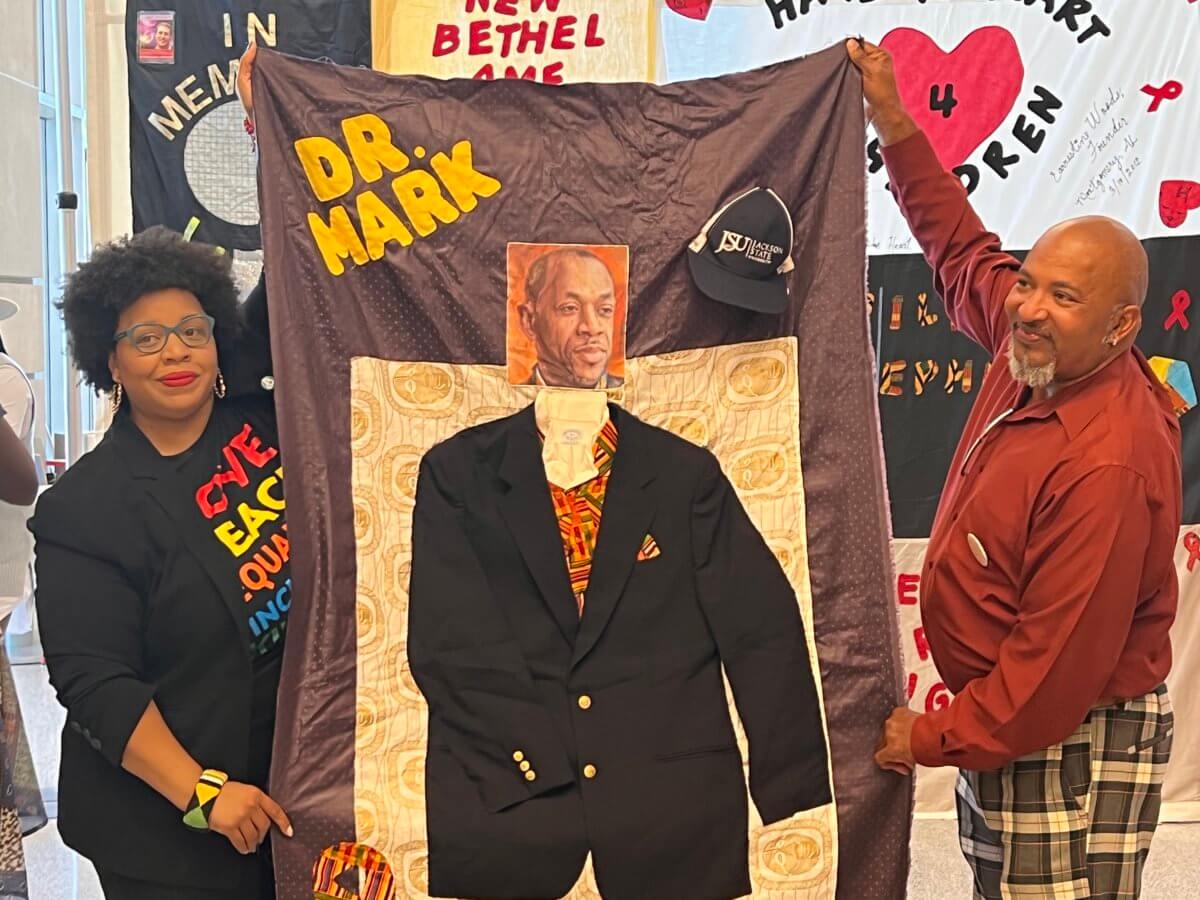 Dafina Ward, left, executive director of the Southern AIDS Coalition, and Cedric Sturdevant, right, co-founder of the Community Health-PIER, holding the panel of JSU Professor Mark Colomb that they created together for the AIDS Memorial Quilt.