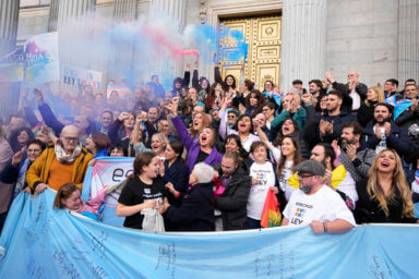 People celebrate the new Transgender Law on the steps of the parliament in Madrid, Spain