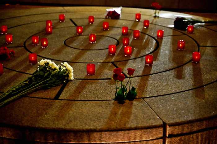 Candles and flowers rest at the NYC AIDS Memorial on World AIDS Day in 2022.