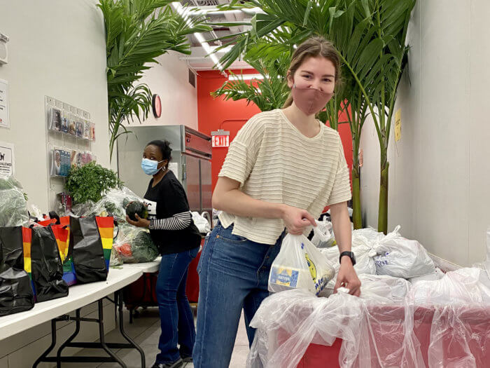 GMHC staffer Donna Pine, background, and GMHC Director of Nutrition and Meals Grace Holihen, foreground, pack grocery bags for community members.