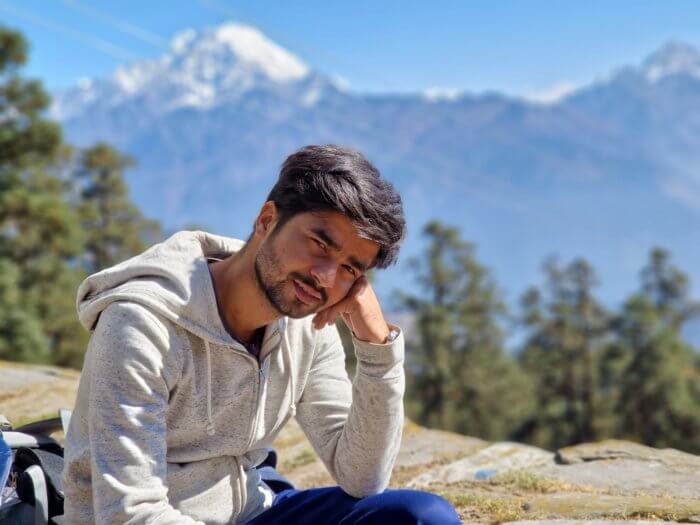 Sagar Ghimire poses in front of mountains.