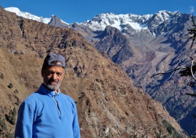 Nepali filmmaker and LGBTQI activist Sunil Babu Pant stands in front of mountains.