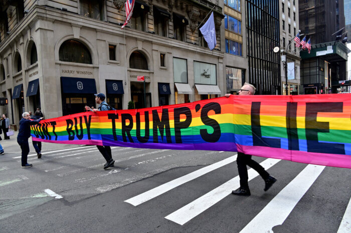 Gilbert Baker's "DON'T BUY TRUMP'S LIES" banner crosses the street.
