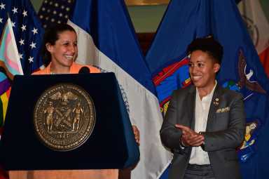 The event's hosts and co-chairs of the LGBTQIA+ Caucus, Tiffany Caban and Crystal Hudson, stand at the podium.