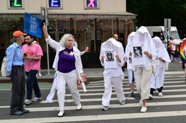 Human Beings cross the street during a remembrance of the Pulse victims.