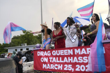 Nic Zantop, left, waves a Trans Flag while on a float sponsored by several transgender groups, with Tiffany Arieagus, second from left, and Miss Naples Pride Velvet Lenore, second from right, during the Stonewall Pride Parade and Street Festival, Saturday, June 17, 2023, in Wilton Manors, Fla.