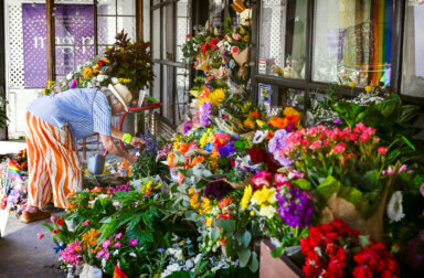 Cedar Glen community member Trish Forest leaves flowers for Laura Ann "Lauri" Carleton outside Mag.Pi, the store she owned and operated, on Tuesday, Aug. 22, 2023.