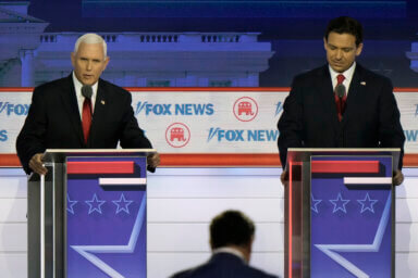 Former Vice President Mike Pence speaks as Florida Gov. Ron DeSantis listens during a Republican presidential primary debate hosted by FOX News Channel Wednesday, Aug. 23, 2023, in Milwaukee.
