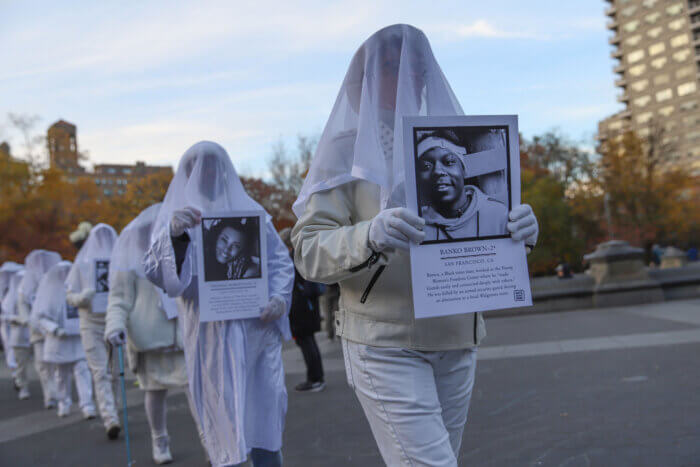 Members of the activist group Gays Against Guns, veiled and dressed in white, silently honored the lives and stories of 22 trans people who were killed by gun violence in the past year.