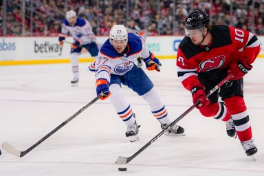 New Jersey Devils right wing Alexander Holtz (10) is defended by Edmonton Oilers left wing Warren Foegele (37) during the second period of an NHL hockey game in Newark, N.J., Thursday, Dec. 21, 2023. ()