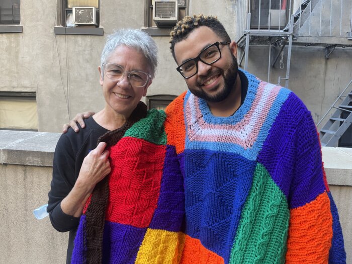 Austin Rivers, founder of Knit the Rainbow, with Rose de Klerk, a volunteer who knitted his rainbow poncho.
