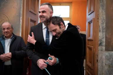 Greek author Petros Hadjopoulos, who uses the pen name Auguste Corteau, hugs his husband, lawyer Anastasios Samouilidis, before their wedding at Athens City Hall, Greece, on Thursday, March 7, 2024.