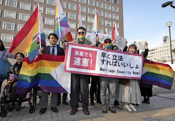 Plaintiffs and others show a banner in front of Sapporo Hight Court in Sapporo, Hokkaido, northern Japan Thursday, March 14, 2024.