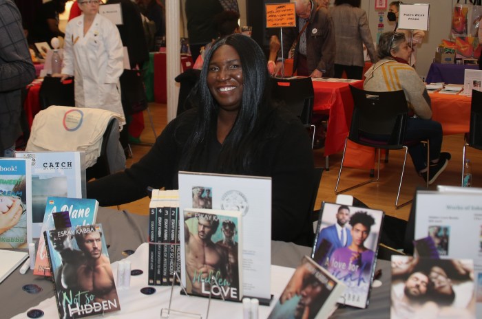 Romance writer Eskay Kabba shows off some of her books at the Rainbow Book Fair.
