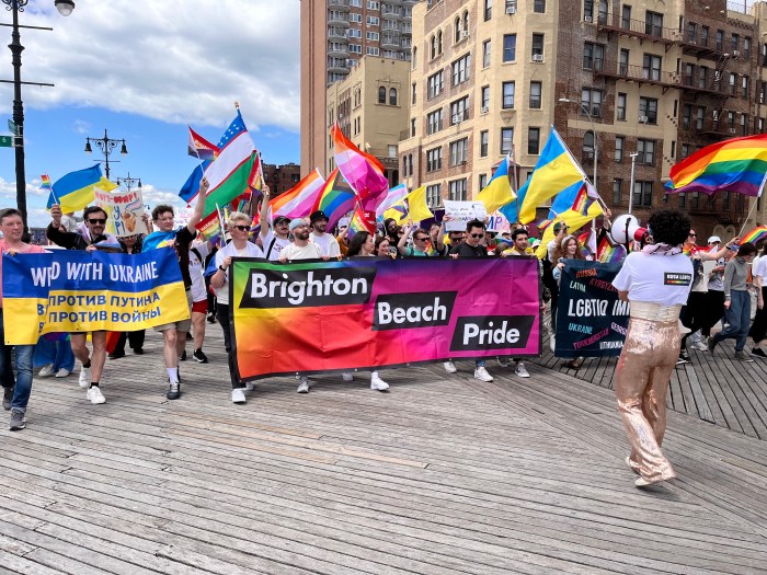Brighton Beach Pride's lead banner moves along the Riegelmann Boardwalk in southern Brooklyn.