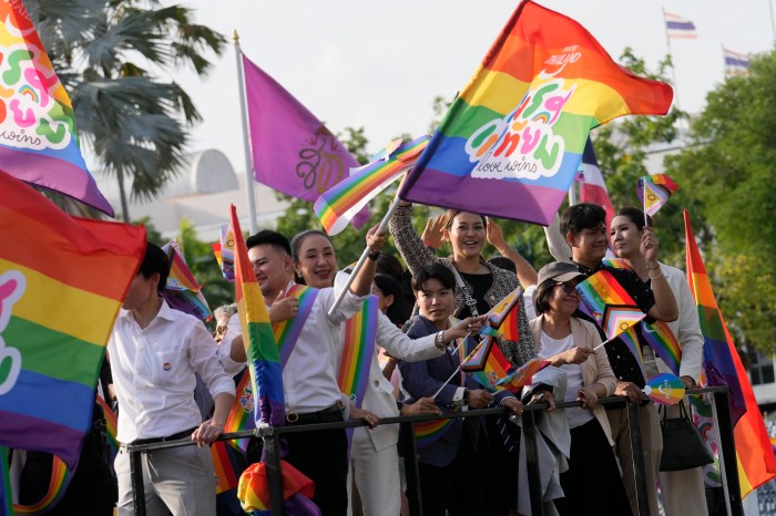 Participants wave flags celebrating equality in marriage at government house in Bangkok, Thailand, Tuesday, June 18, 2024.
