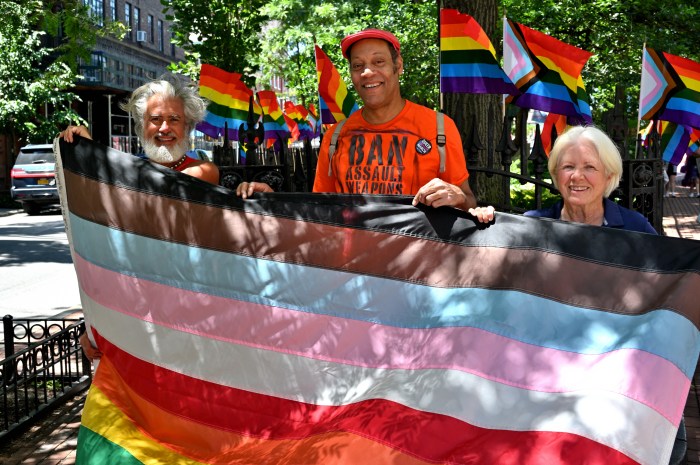 Steven Love Menendez, Jay W. Walker, and Ann Northrop hold the large Rainbow Flag before installing it on the flagpole.