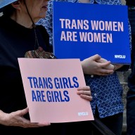 An individual at holds a sign at the Nassau County Legislative Building during a demonstration against the county's anti-trans sports policy.