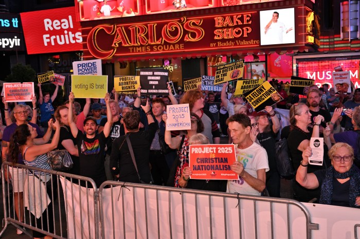 Activists protest against the backdrop of the Times Square lights.