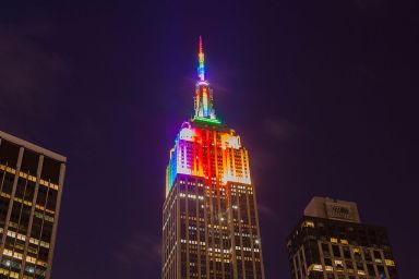 Empire State Building lit up in rainbow colors.