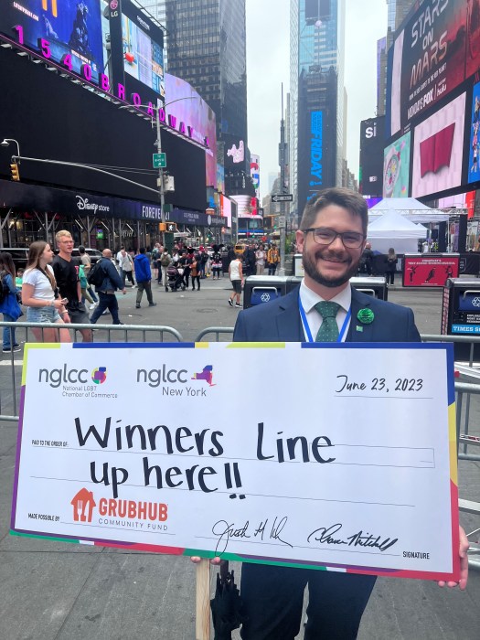 nglccNY’s executive director, Barton L. Jackson II, holds a check from a GrubHub/nglccNY initiative.