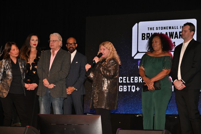 Stonewall Inn co-owner Stacy Lentz speaks to the audience alongside the Stonewall Inn Give Back Initiative's board members.